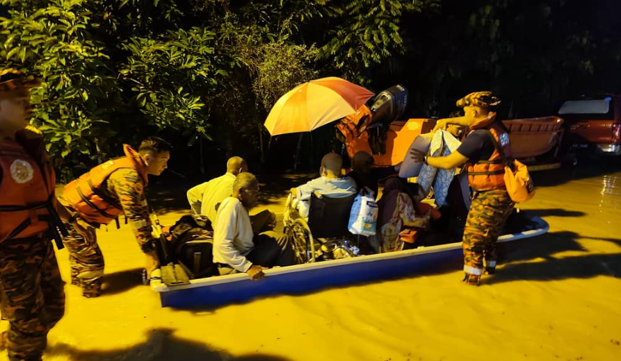 Bomba menyelamatkan penduduk terjejas yang terperangkap di sebuah dusun yang dinaiki air akibat limpahan sungai di Kampung Wang Perah / Foto JBPM